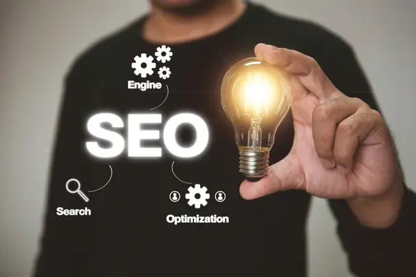 A man holding a light bulb with the word seo on it.